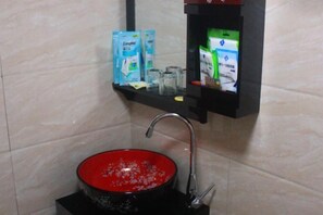 A bathroom with a red basin, a faucet, and shelves holding toiletries. - Xinyuan Mengya Inn (Langzhong)