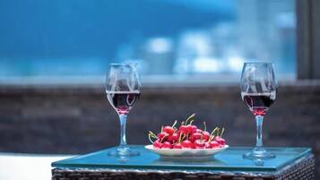 Una mesa con dos copas de vino y un plato de cerezas.