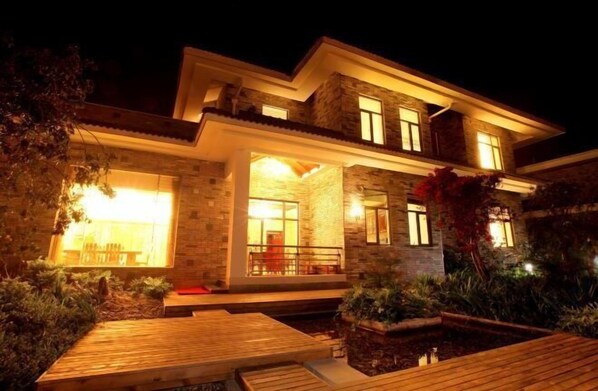 A modern house with a well-lit entrance, a covered porch, and a landscaped garden. - Landu Business Hotel (Tengchong)