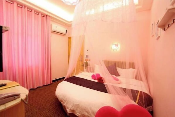 A hotel room with a bed, a bedside table, a chair, a curtain, and a window.