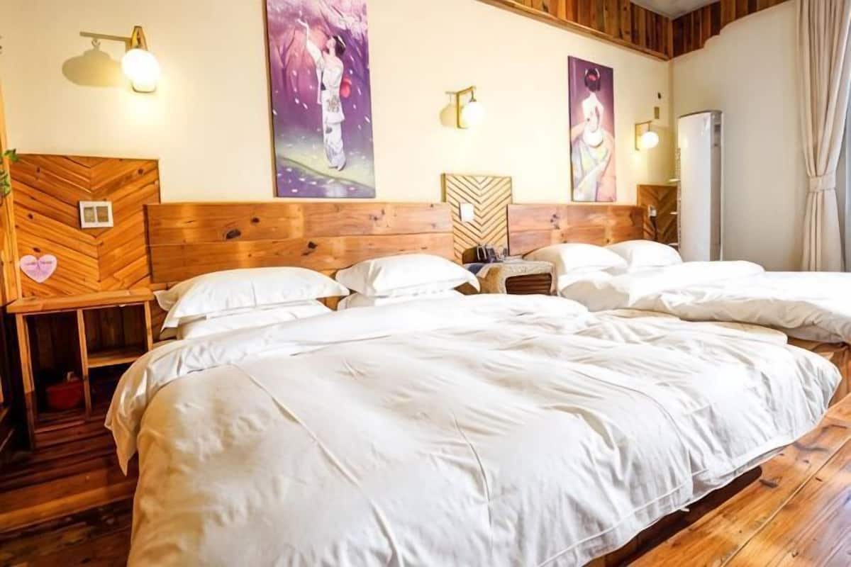 Habitación de hotel con una cama grande, cabecera de madera, dos mesitas de noche y lámparas fijadas a la pared.