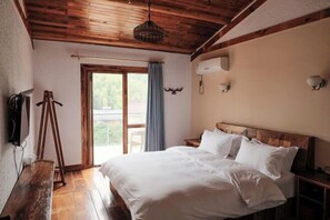 A bedroom with a wooden ceiling, a bed with white bedding, a bench, a window with curtains, and wall-mounted lights. - Yunshe Inn (Deqing)