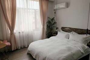 A bedroom with a bed, curtains, a plant, and an air conditioning unit. - Yunshe Inn (Deqing)