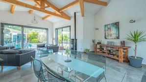A spacious living area with a glass dining table, sofas, and a wooden ceiling. - La Provence et ses cigales (Ceyreste)