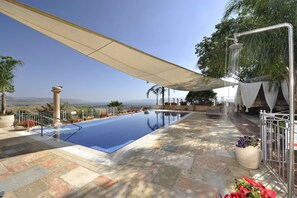 A swimming pool with a view of the mountains, a covered seating area, and potted plants. - Accommodation Units The Mansion Had Nes (Had Nes)