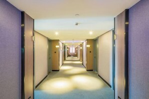 A hotel corridor with doors on both sides, leading to rooms. - Huilong Hotel (Tiantai County)