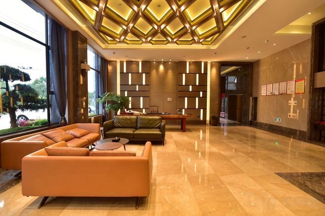 A modern lobby with a sectional sofa, a coffee table, and a potted plant.