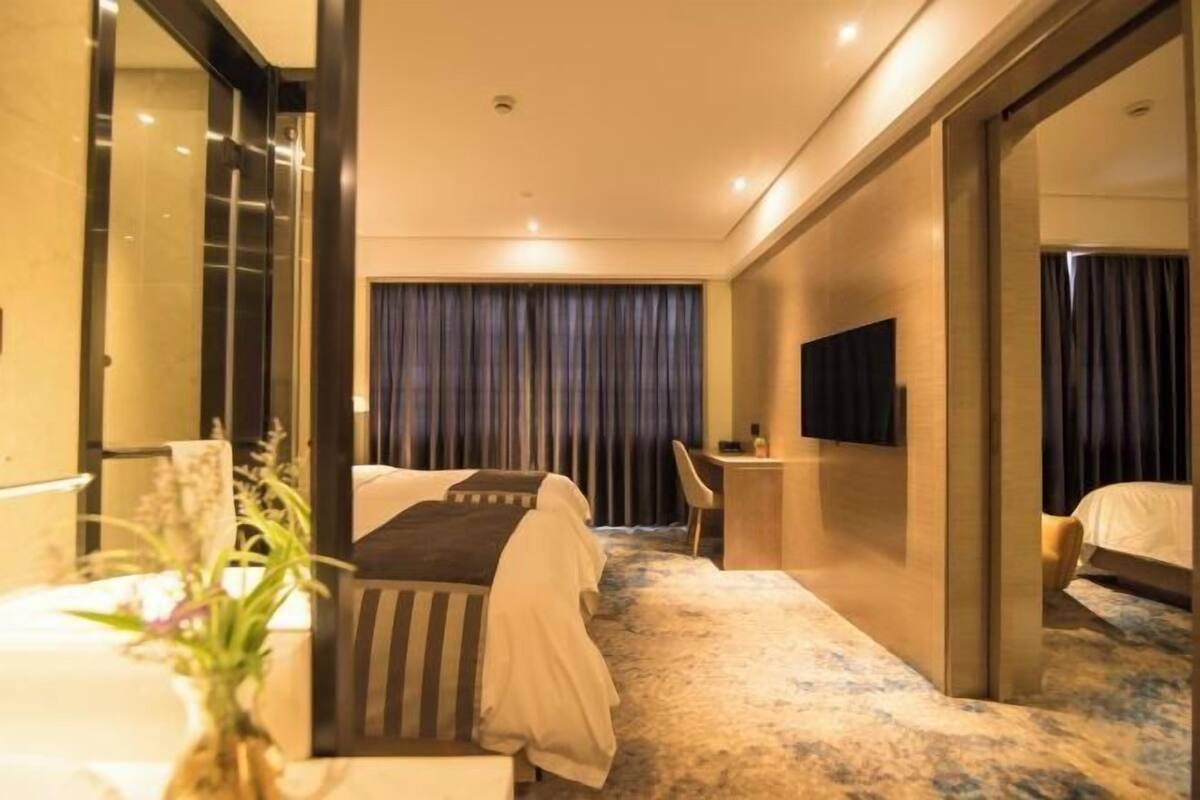 Une chambre d’hôtel équipée d’un lit, d’un bureau, d’une chaise et d’un téléviseur.