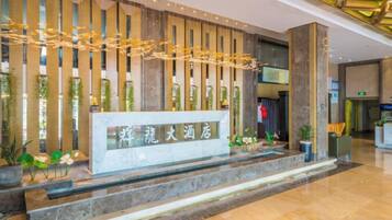 A reception area with a reception desk, vertical wooden panels, and decorative lighting.