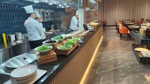 Una mesa de buffet con varios platos y una larga barra.