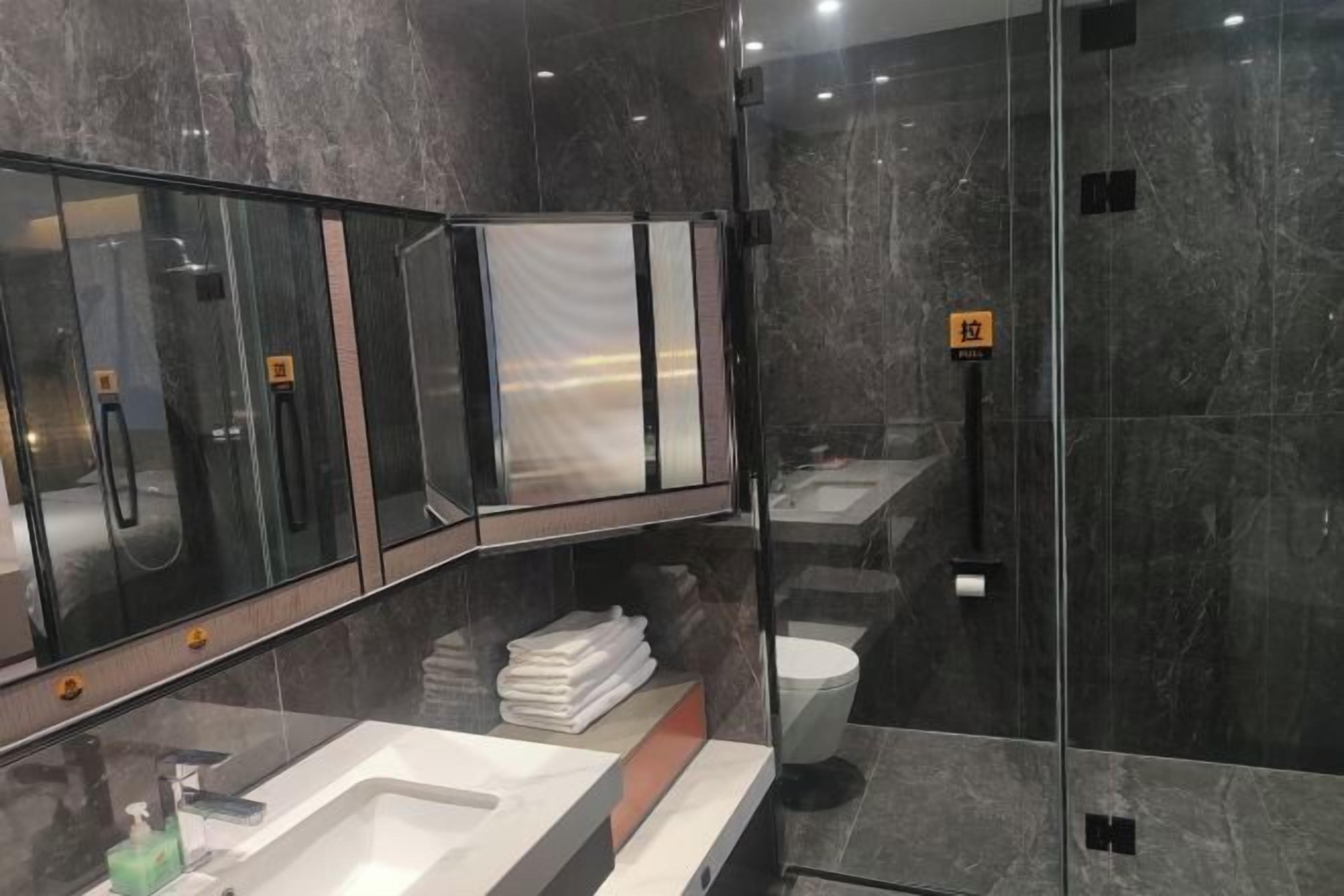 A modern bathroom with a glass-enclosed shower, a vanity with a sink, and a toilet.