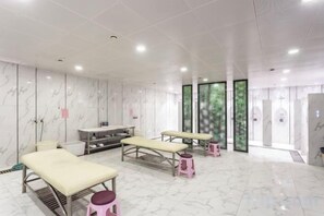 Una clínica médica moderna y limpia con camillas de exploración, zona de recepción y grandes ventanales.