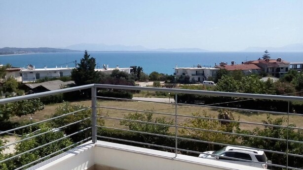 Uma varanda com vista para o mar e edifícios.