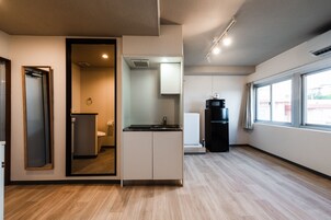 Une cuisine moderne équipée d’une cuisinière intégrée, d’un évier et d’un réfrigérateur. Une fenêtre laisse entrer la lumière naturelle et offre une vue sur l’extérieur.