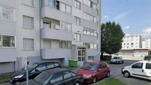 A multi-story residential building with a parking area in front. - 3 rooms Grenoble - Saint Martin d'heres (Saint-Martin-d'Hères)