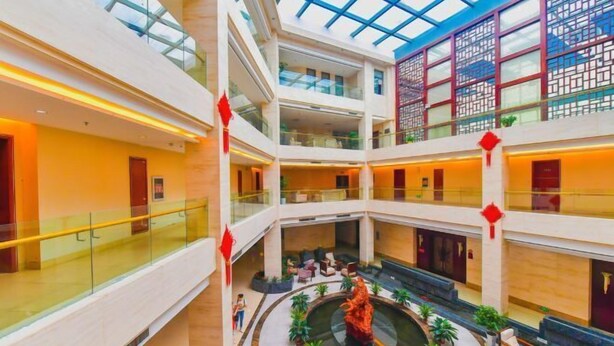 A multi-level atrium with glass railings, a central water feature, and seating areas. - Daohuaxiang Hotel (Yichang)