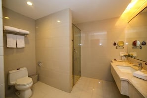 A modern bathroom with a toilet, shower, and sink.