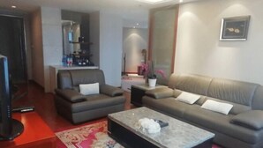 A modern living room with a sofa, a coffee table, and a TV. - Daohuaxiang Hotel (Yichang)