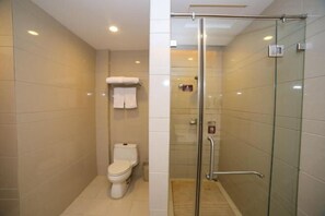 A modern bathroom with a glass shower enclosure, a toilet, and a towel rack. - Daohuaxiang Hotel (Yichang)