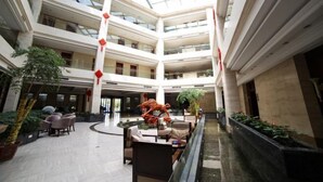 A multi-level atrium with a central water feature, seating areas, and potted plants. - Daohuaxiang Hotel (Yichang)