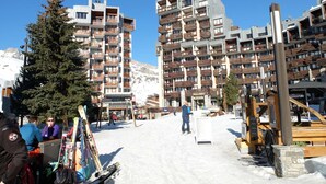 A ski resort with multi-story buildings, ski lifts, and a snowy landscape.