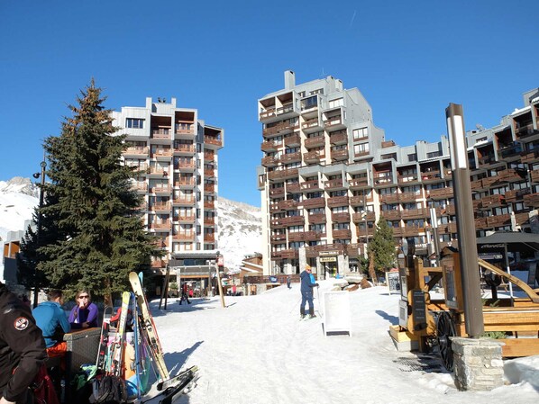A ski resort with multi-story buildings, ski lifts, and a snowy landscape.