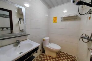 Un baño con lavamanos blanco, inodoro y ducha.