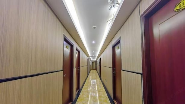 Un pasillo de hotel con paredes de madera, suelo de mármol y puertas con el símbolo de número.