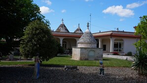 Un bâtiment avec un toit recouvert de tuiles rouges, des tours en pierre et une statue au premier plan.