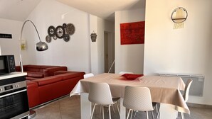 A modern kitchen with a microwave, oven, and a red sofa. - Bright house villa (Andernos-les-Bains)