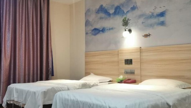 A hotel room with two beds, a large painting of mountains and birds on the wall, and a curtain. - Zhixing Business Hotel (Quanzhou)