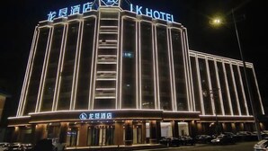 A hotel with a prominent 'LK HOTEL' sign, a vertical light strip design, and a visible entrance with cars parked outside. - Longken Bei'an Hotel (Bei'an)