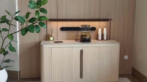 A light-colored cabinet with a shelf, a small plant, and a few items on top. - Longken Bei'an Hotel (Bei'an)