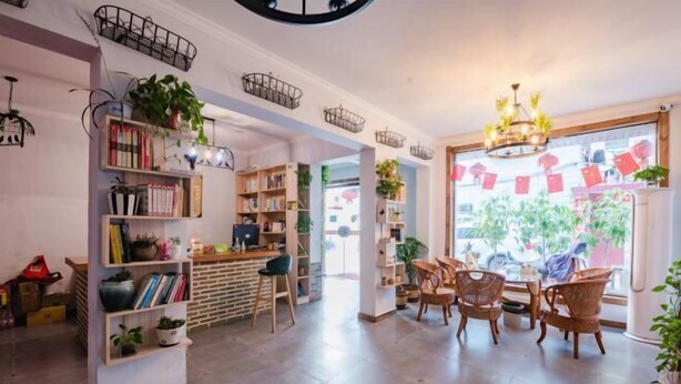 A cozy interior with a central seating area, bookshelves, and decorative baskets. - Qiqi Inn (Xinyang)