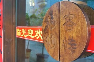 Una puerta de madera con un cartel delante.