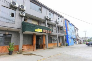A building with a green awning and a sign that reads '旅館'. - Chengzhong Xiaozhu Holiday House (Zhangjiajie Tianmenshan Bus Station Railway Station) (Zhangjiajie)