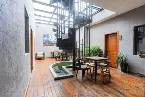 A spacious indoor area with a wooden floor, a small water feature, and a staircase leading to an upper level. - Chengzhong Xiaozhu Holiday House (Zhangjiajie Tianmenshan Bus Station Railway Station) (Zhangjiajie)