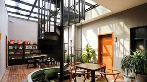 A modern interior with a dining area, a staircase, and a bookshelf.