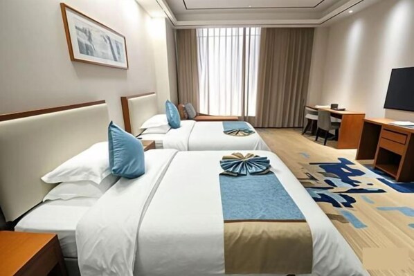 A hotel room with two beds, a desk, a chair, and a television.