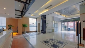 A spacious lobby with a reception desk, a large potted plant, and a modern ceiling design. - Fulante Le Hotel (Zhangjiajie Pedestrian Street) (Zhangjiajie)