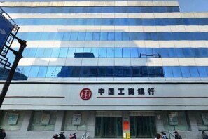 A modern building with a reflective glass facade and a prominent logo at the entrance. - Fulante Le Hotel (Zhangjiajie Pedestrian Street) (Zhangjiajie)
