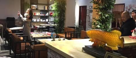 A reception area with a reception desk, chairs, and a large fish decoration.