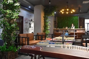 Een modern interieur met zithoeken, een receptiebalie en een groene wand.