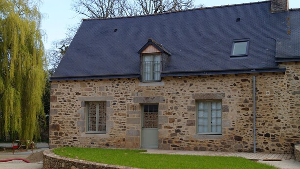 A stone building with a sloped roof, a small window, and a door. - Les Anémones (Lamballe)