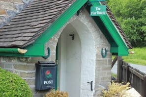 A stone building with a green roof and a sign reading "The Pike House."