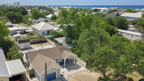 Un barrio residencial con casas, una piscina y vistas al océano.