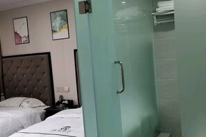 A hotel room with a bed, a glass shower enclosure, and a wall-mounted towel rack. - Jiguang Hotel (Chongqing)