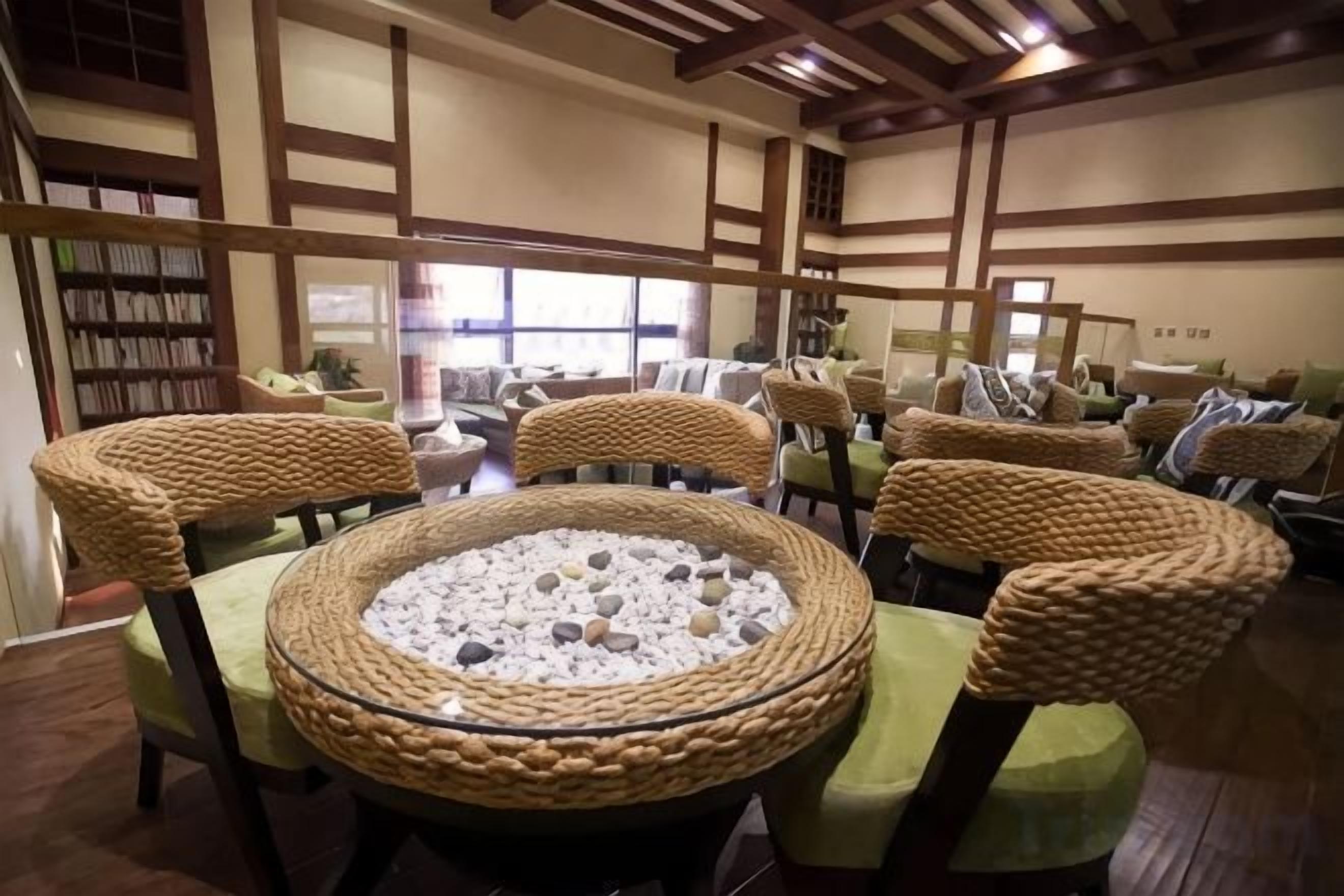 A traditional Japanese-style room with tatami mats, low wooden tables, and woven chairs.