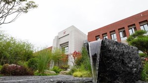 A waterfall feature in a landscaped area with a building in the background. - Zhaojin Shuyuan Hotel (Tongchuan)