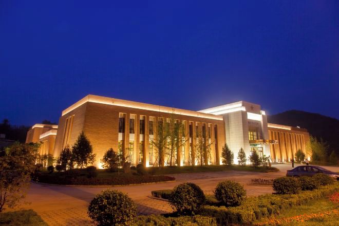 A large building with a modern architectural style, featuring a prominent entrance and a well-lit facade.